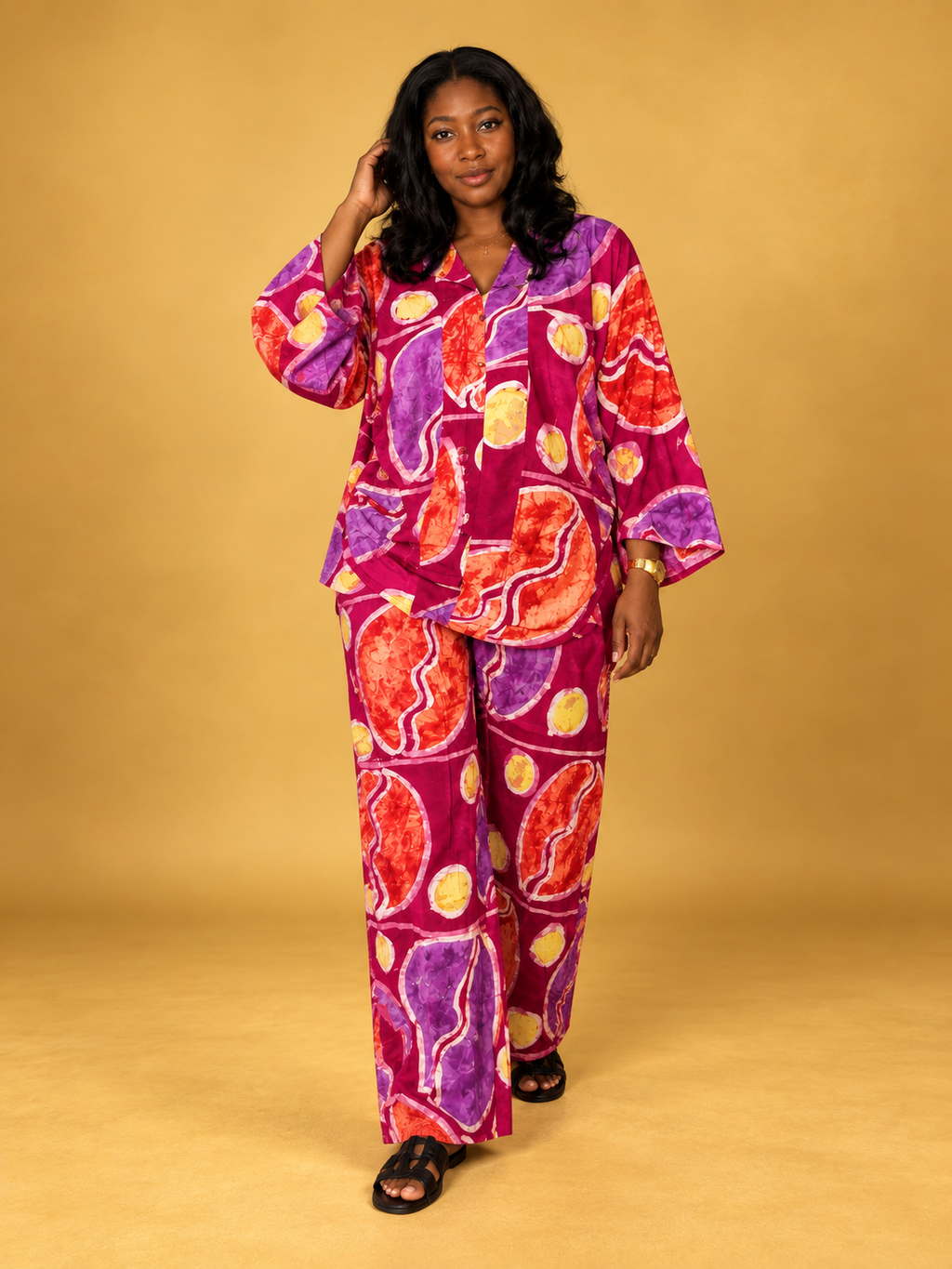 Model wearing the Ajoke 2 Piece Set in vibrant magenta, purple, orange and yellow batik print by ILÉ AYỌ̀KÁ.