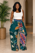 Model wearing teal batik wide-leg pants with multicolor print, layered panels and tassel details by ILÉ AYỌ̀KÁ.