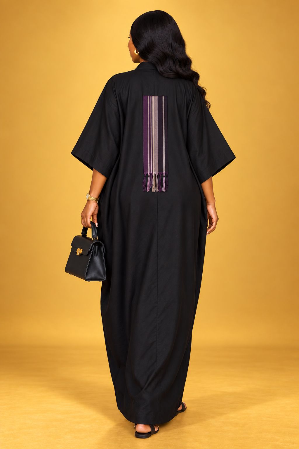 Model wearing a purple, yellow, black and white batik maxi bubu dress by ILÉ AYỌ̀KÁ.